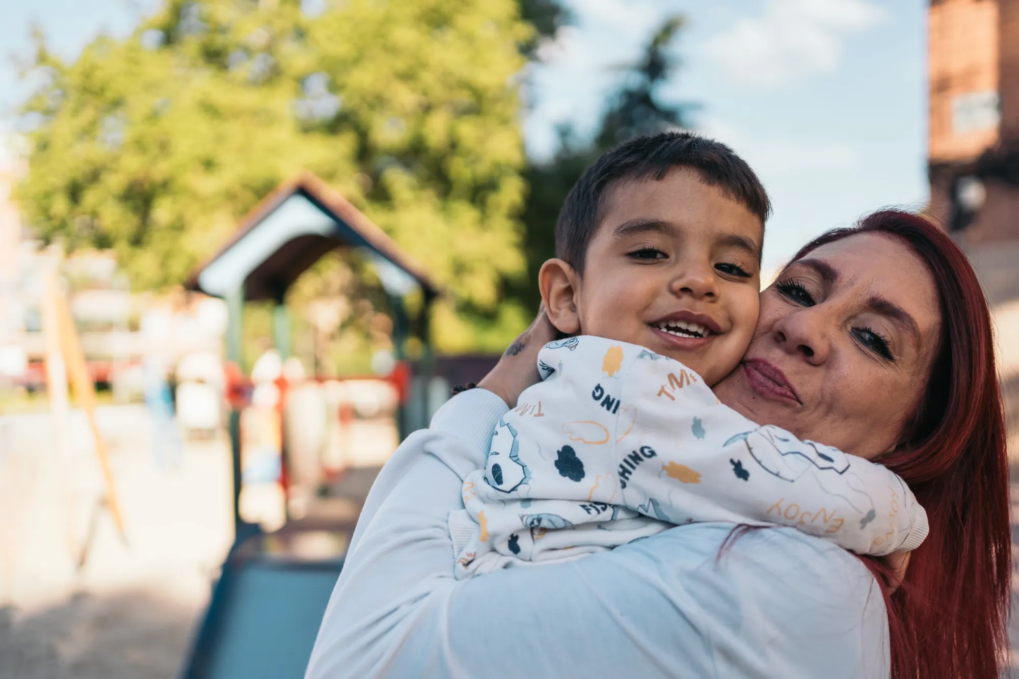 Mãe abraçando criança com autismo, beneficiária do BPC LOAS, que apoia famílias em condição de baixa renda