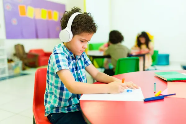 Criança com autismo em sala de aula,  beneficiária do BPC LOAS para pessoas com autismo